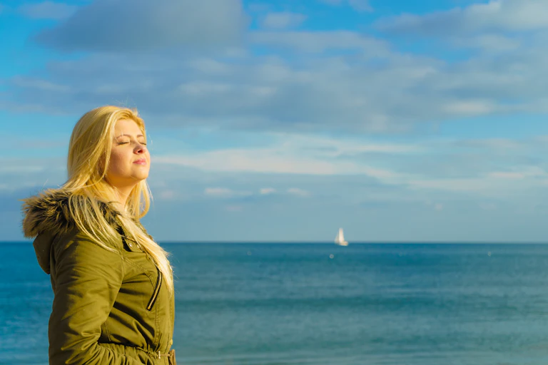 A woman enjoys the sun on a winter's day.