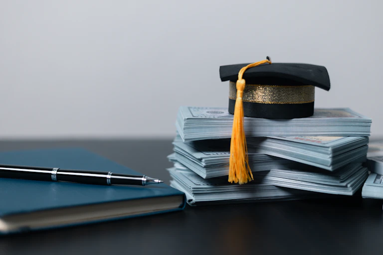 A graduation cap on top of money.