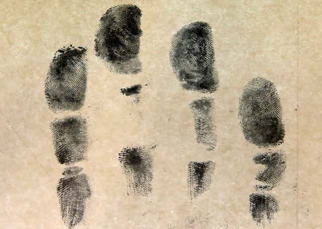A handprint, shown in dark gray, against a tan background. 