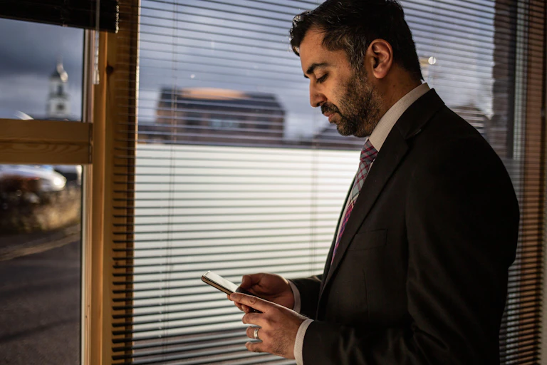 Humza Yousaf looking at his phone