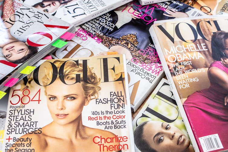 A pile of Vogue magazines on top of each other.