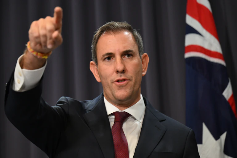 Man standing at lectern motioning to an audience