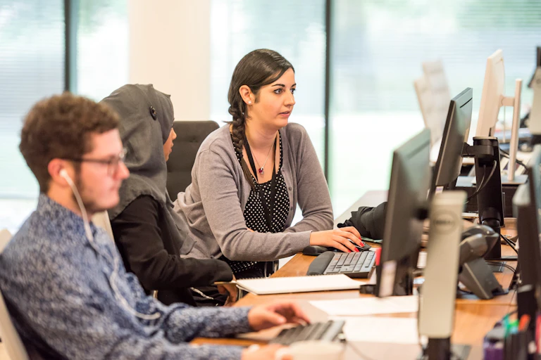 Workers typing at desks, looking distracted