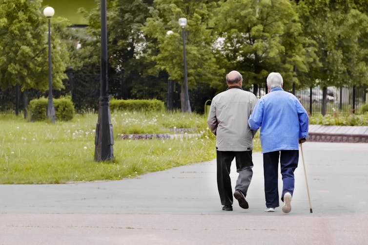 Two older people walk together