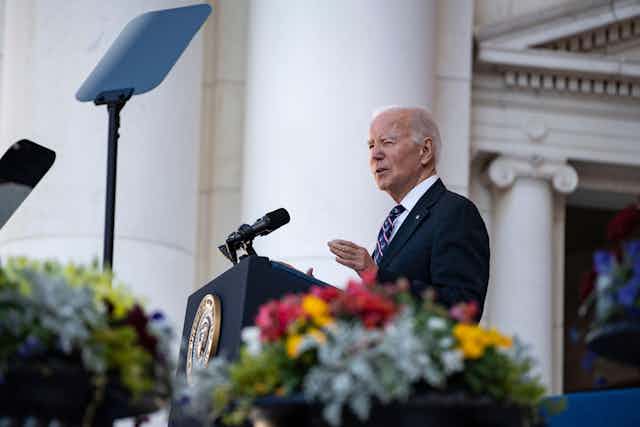 Joe Biden standing at a podium speaking.