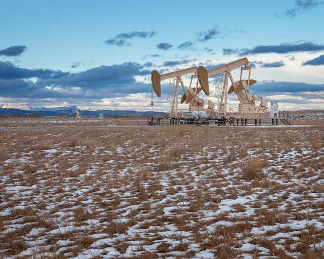 Oil wells on a snowy plain.