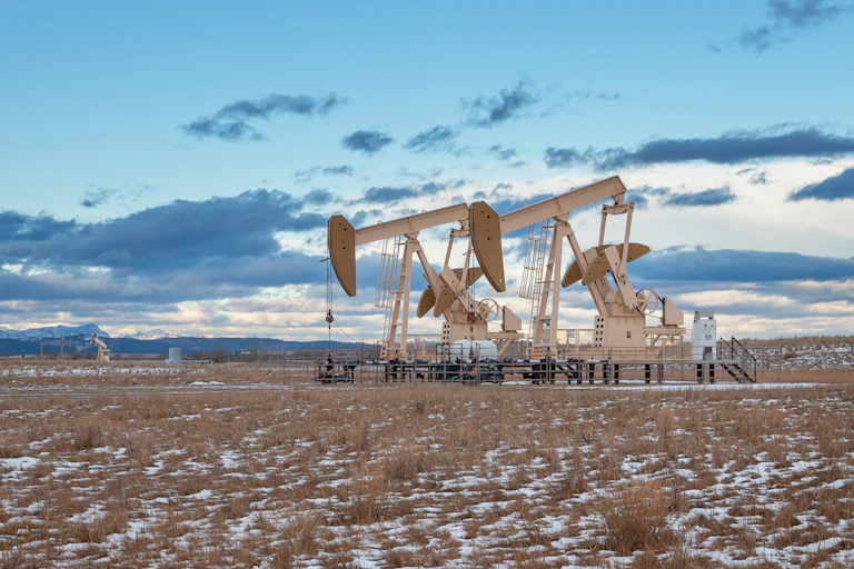 Oil wells on a snowy plain.