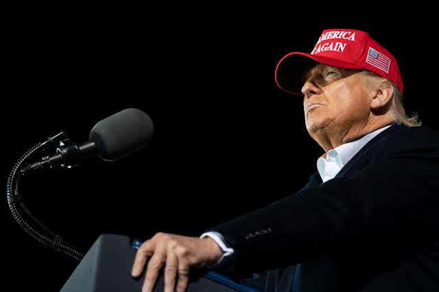 Donald Trump in a red cap with Make America Great Again on it.