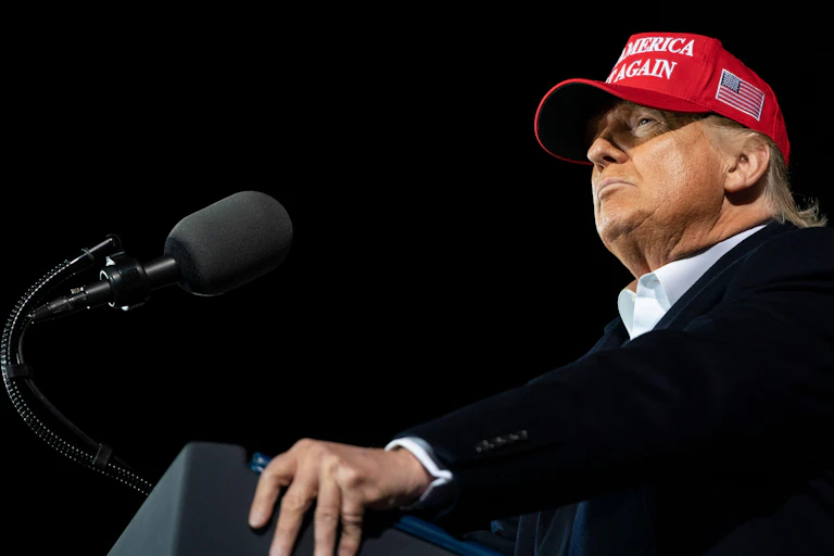 Donald Trump in a red cap with Make America Great Again on it.
