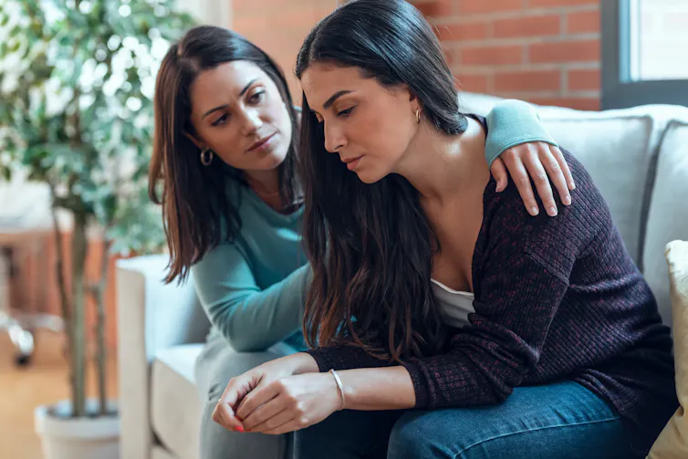 A woman comforts another woman.