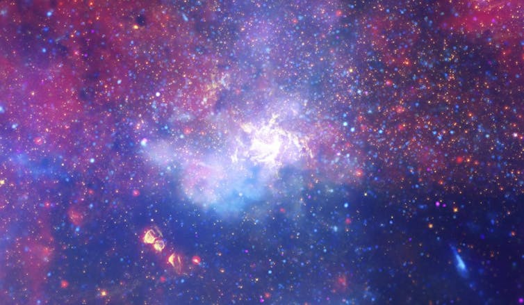 Un enorme remolino de gas caliente brilla con luz infrarroja, marcando la ubicación aproximada del agujero negro supermasivo Sagitario A* en el corazón de la Vía Láctea.