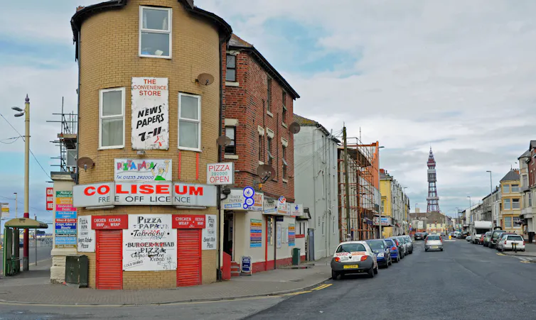 A boarded up shop on a street corner.