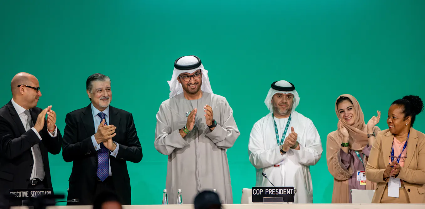 COP28: Five major outcomes from the latest UN climate summit 'a group of men standing in front of a podium clapping'
