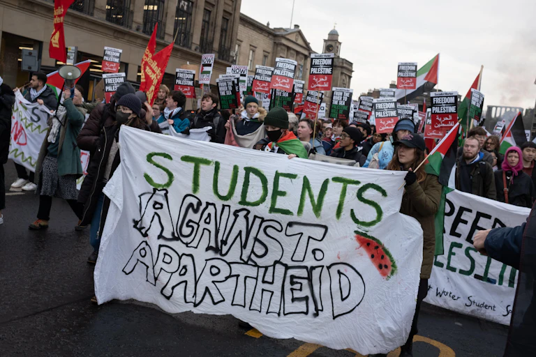 Protesters in Edinburgh hold a banner saying 'Students against apartheid'.