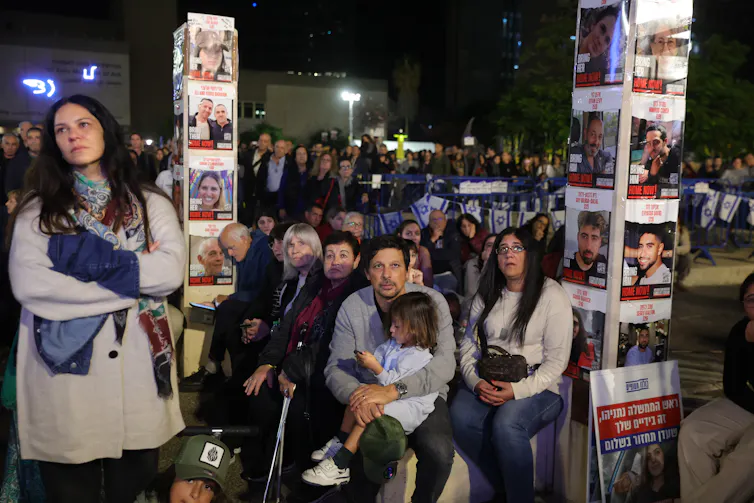 Family members and supporters of Israeli hostages held by Hamas in Gaza, hold up portraits and call for their release