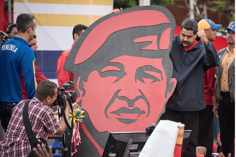 Nicolás Maduro sujeta un retrato de Hugo Chávez.