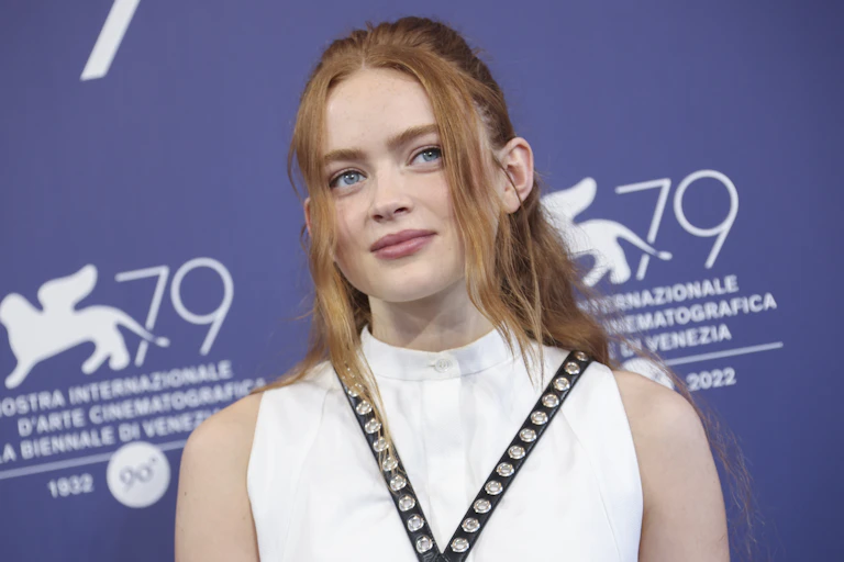 A teen standing in a white dress.