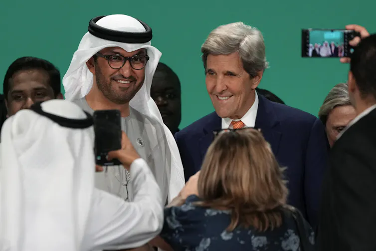 two smiling men being photographed