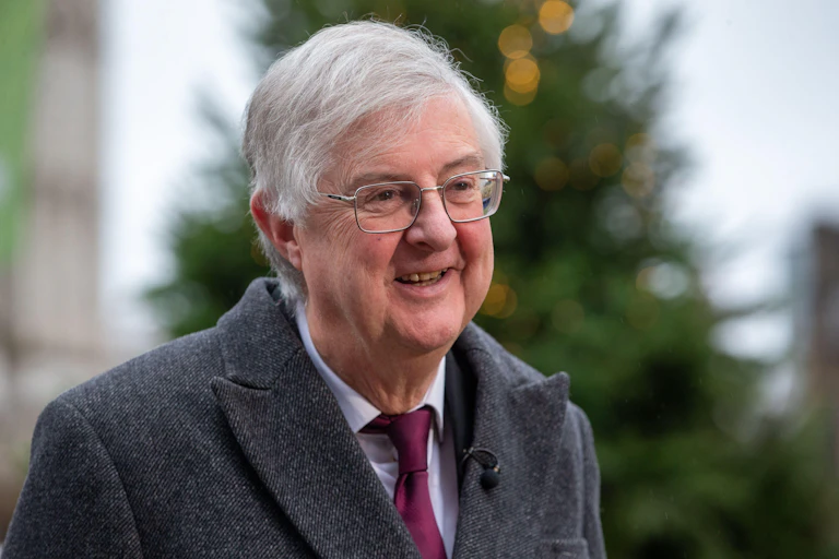 Mark Drakeford smiles and looks to the left of the camera.