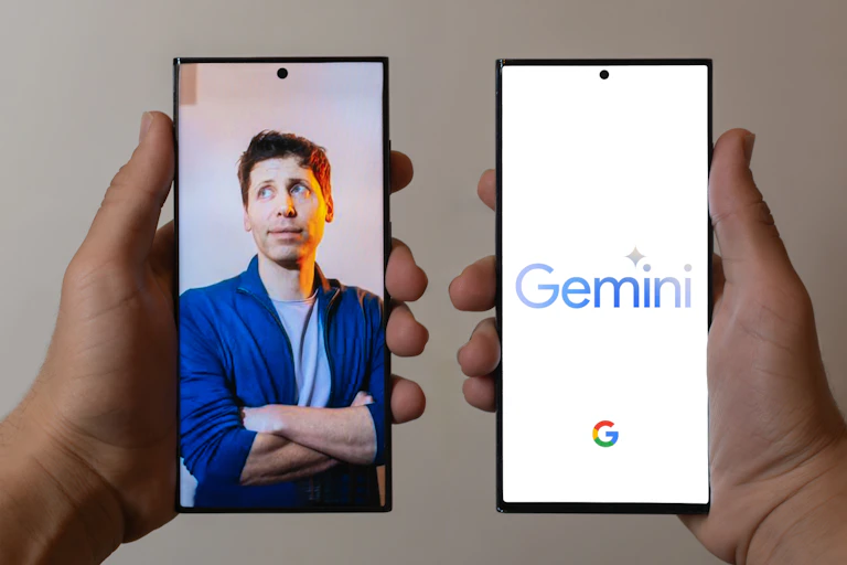Image of two phones, one with a picture of Google CEO Sundar Pichai and one showing Gemini's logo.