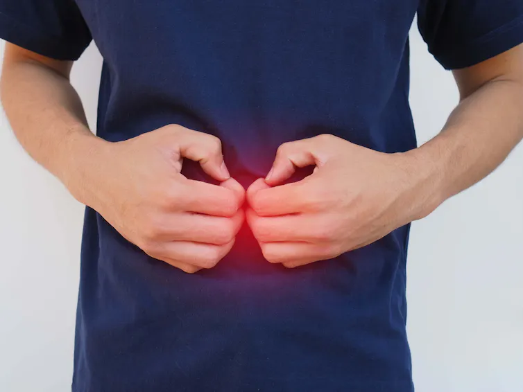 Man holds his abdomen.