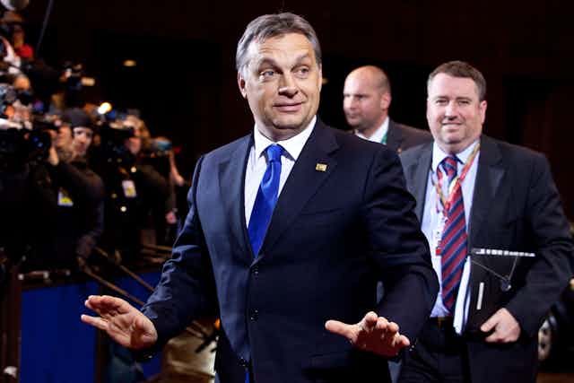 Viktor Orbán wearing a blue suit in front of a crowd.