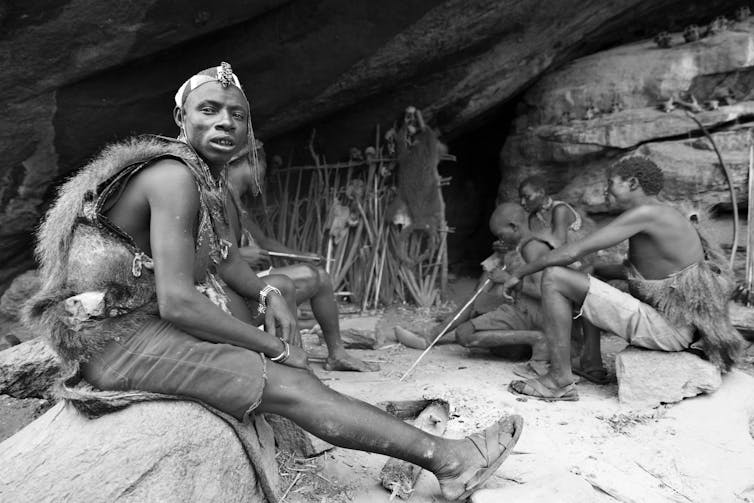 a black and white photo of a group of men sitting