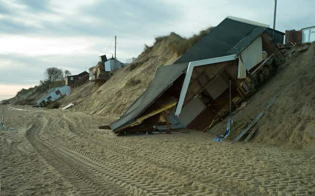 Bungalows destroyed on a beach after a tidal surge.