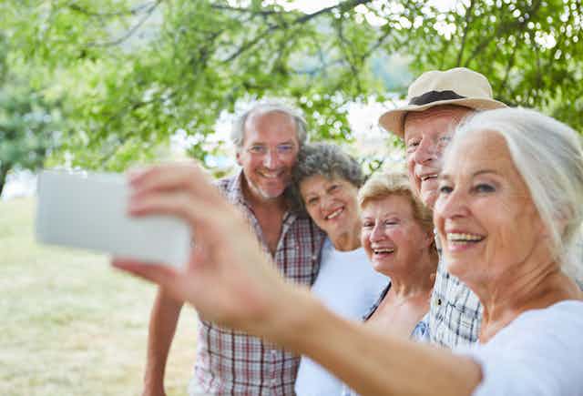 Group of elderly people taking a selfie with a smart phone