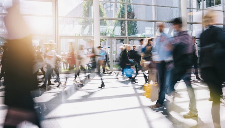 Large crowd of people moving through a foyer