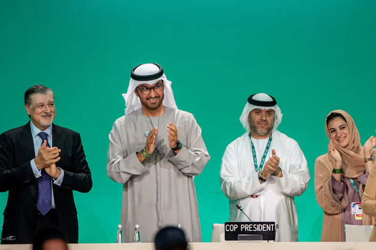 Five people on a podium clapping