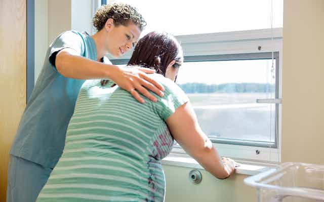 Midwife comforts pregnant woman