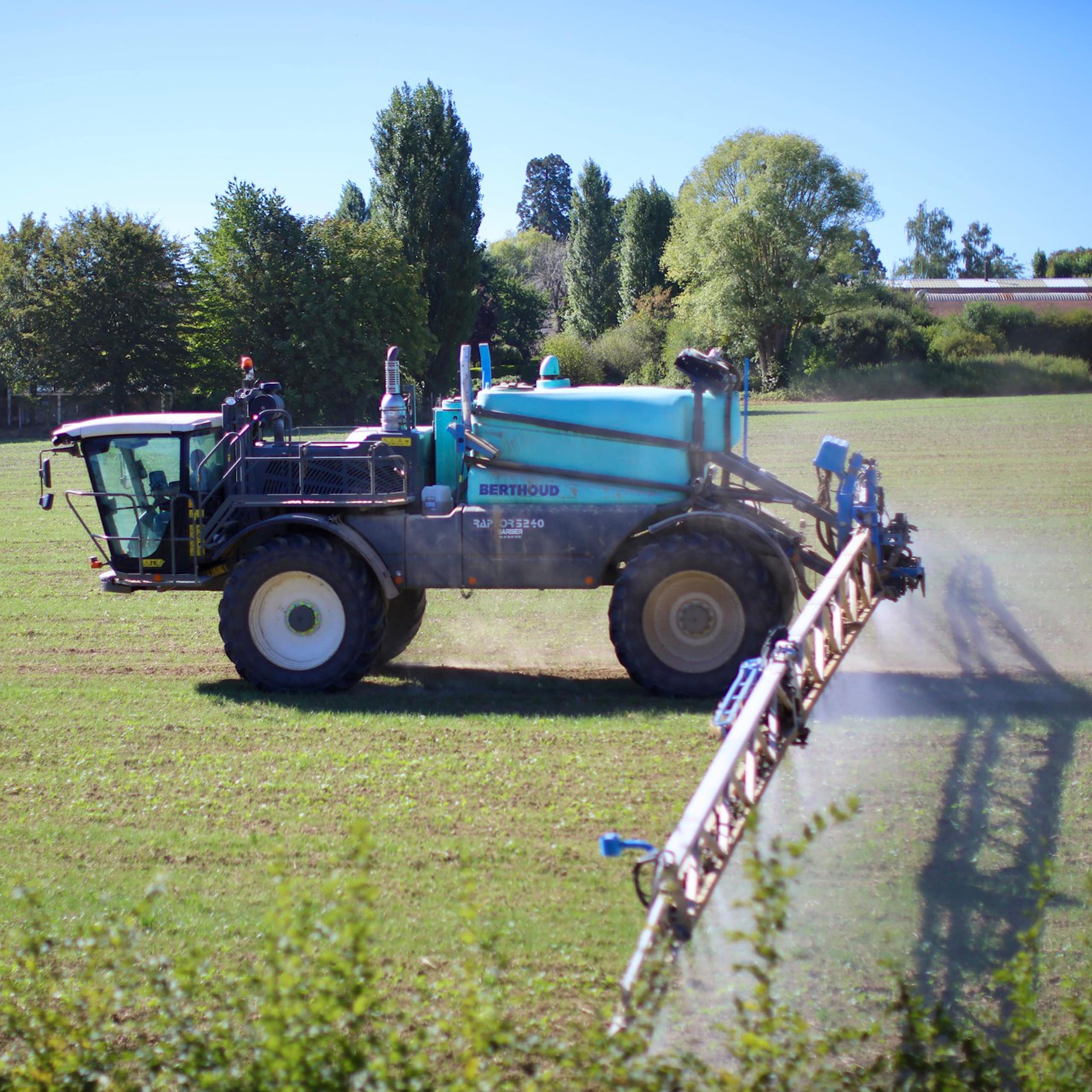tracteur dans un champ qui épande des pesticide