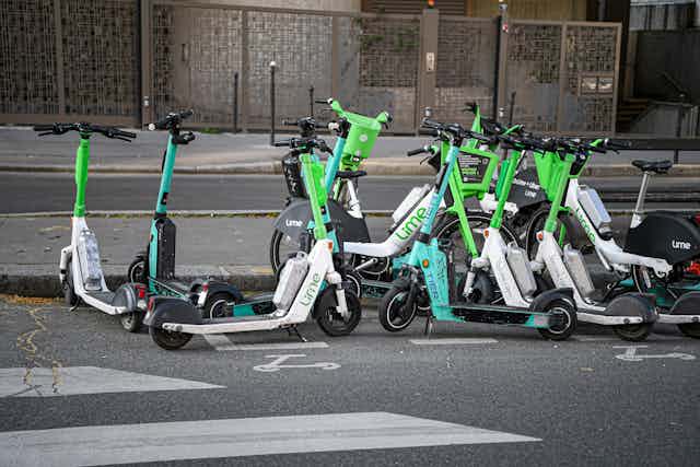 E-scooters gathered by a pavement.