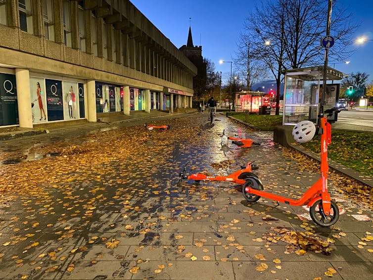 Red scooters on a leafy street in Slough.