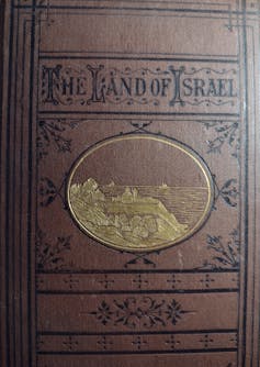 An old brown book cover with the words The Land of Israel.