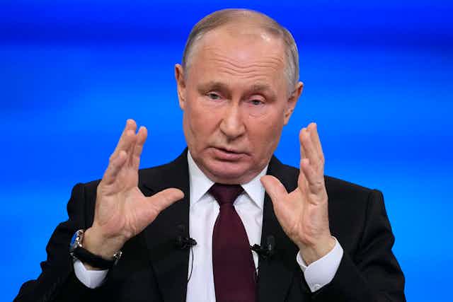 Vladmir Putin gestures with two hands held about 12 inches apart