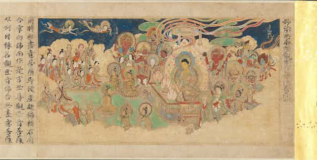 A painted scroll showing multiple figures seated on either side of a central figure, who has a halo around the head.