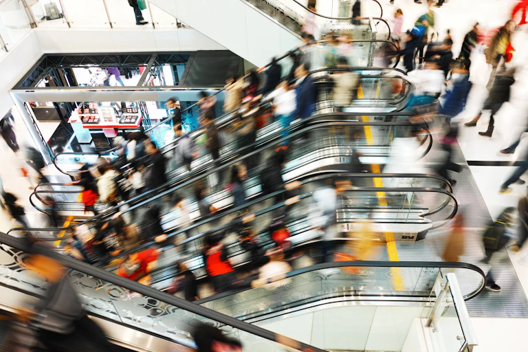 The blurred motion of people on escalators at a centre shopping centre