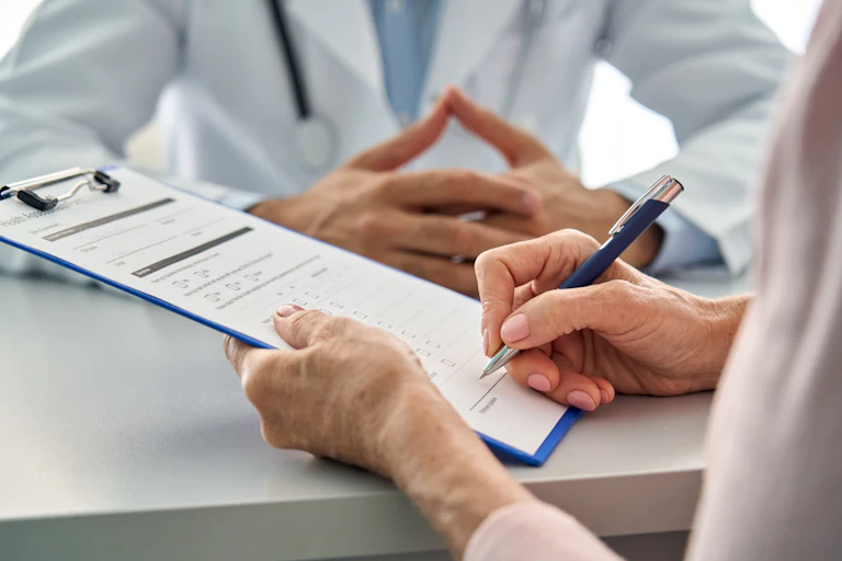 Woman filling in form at doctor's surgery
