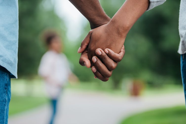 Couple in park holing hands.