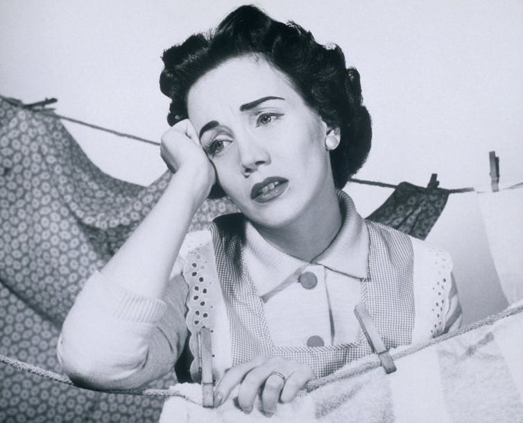 bored 1950s woman hanging out washing