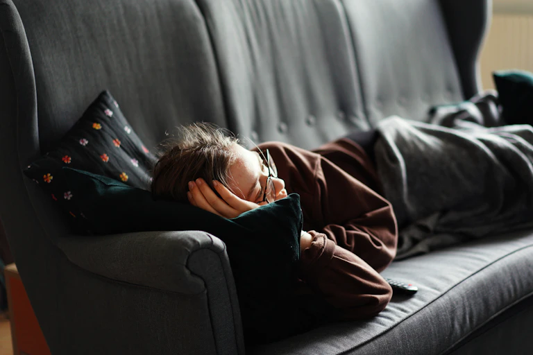 Person lays on their couch, tired