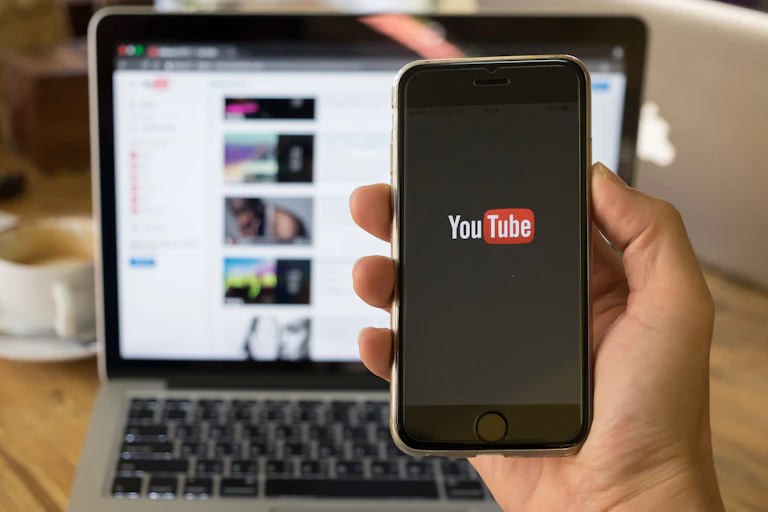 Hand holding phone with YouTube logo