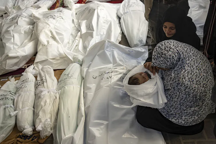 A mother holds her dead baby.