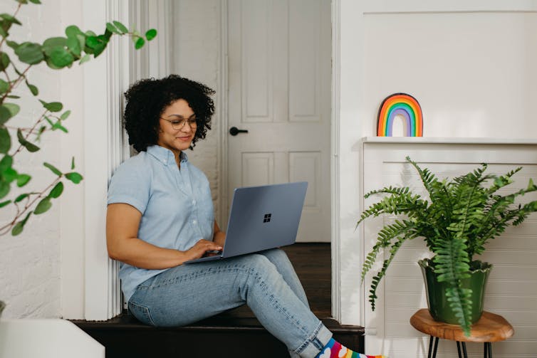 Mother sits on laptop in doorway