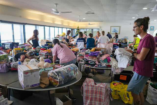Volunteers process donations brought in by residents to assist flood victims at the Cairns Cruising Yacht Squadron evacuation centre in Cairns, Monday, December 18, 2023