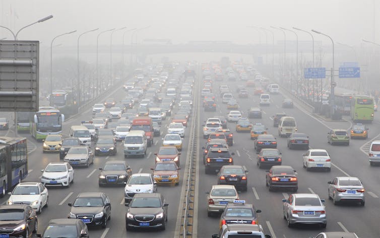 Traffic on a motorway surrounded by heavy smog.