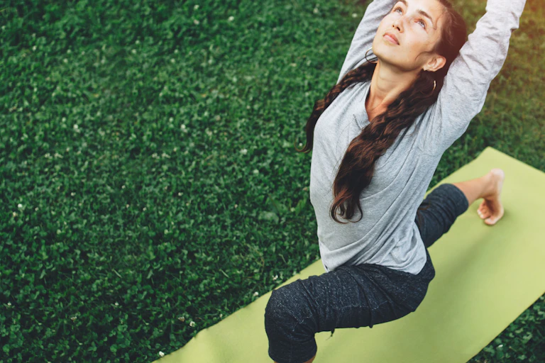 Une femme est debout dans une posture de yoga.