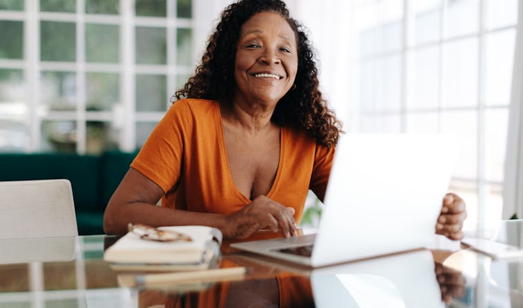 Woman at computer, smiling.